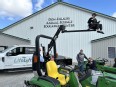 Attendees at the AT Expo learning to use the flatbed truck lift and tractor lift while Marty Cotterman & Ed Sheldon look on
